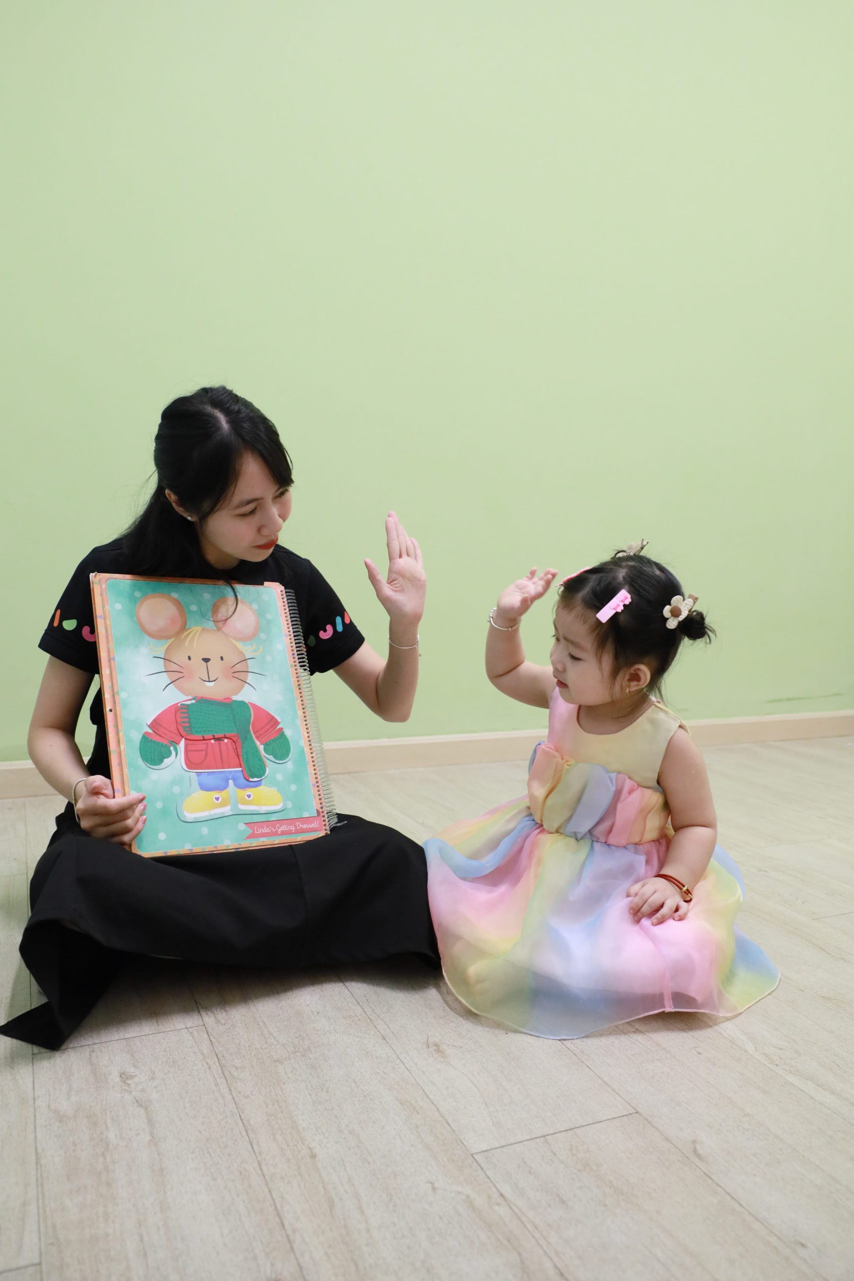 Bé khoe tranh vẽ cùng cô giáo